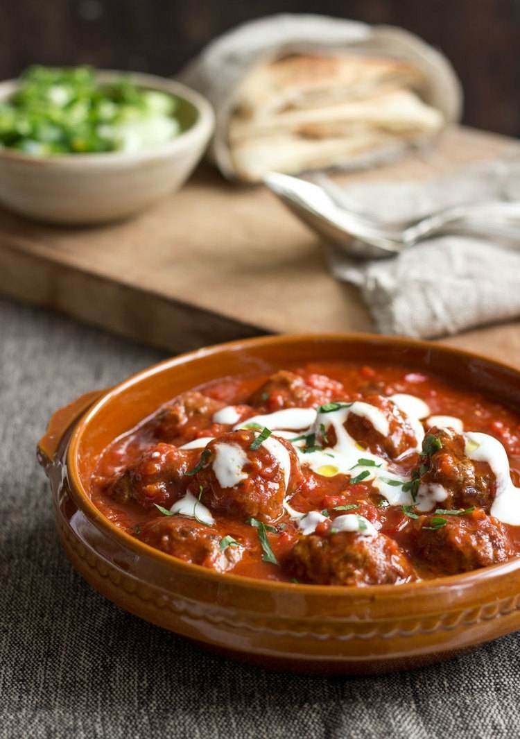 Kombinerede mad-opskrifter-gryderet-hakket kød-tomatsauce-yoghurt-urte-skål-middag-skærebræt-salat