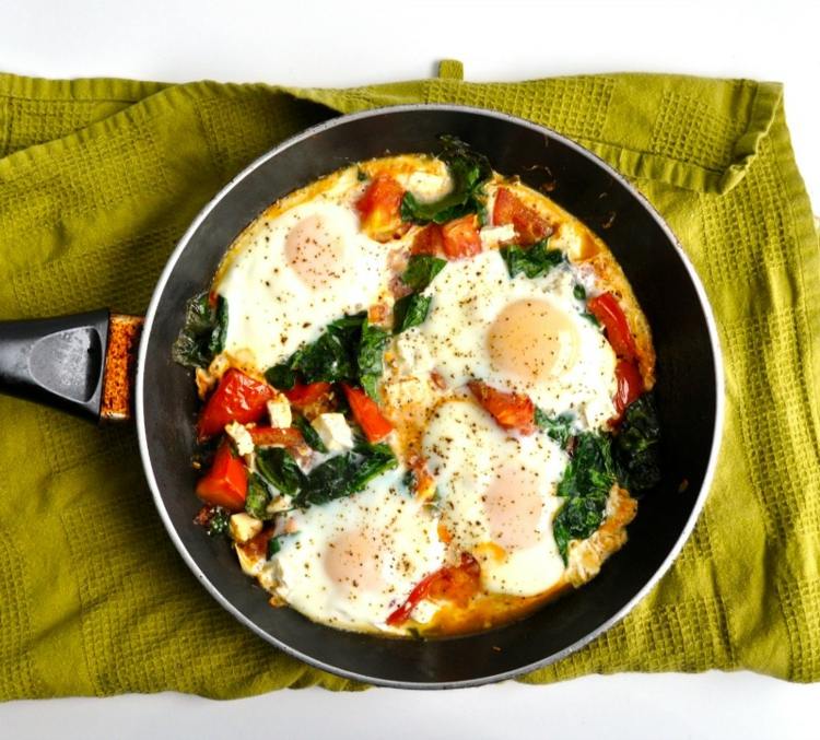 Kombineret mad-opskrifter-stegt æg-spinat-tomat-gryde-køkkenhåndklæde-feta-ost-peber-formalet