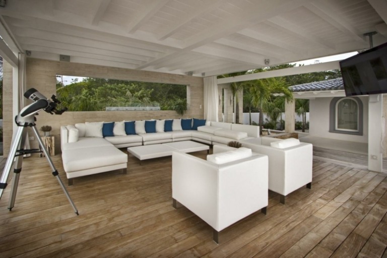 lounge siddegruppe hvid minimalistisk møblering tagterrasse blå kastepuder