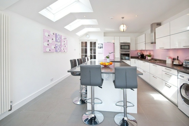 Lofts-lejlighed-køkken-med-vindue-på-loftet-hvide-skabe-med-pink-væg