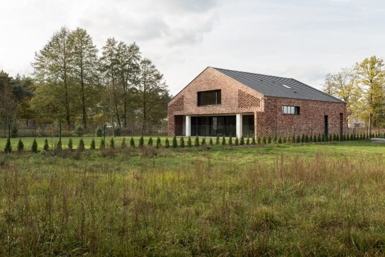 naturlige omgivelser med grønne områder og skov omkring ny murstensbygning