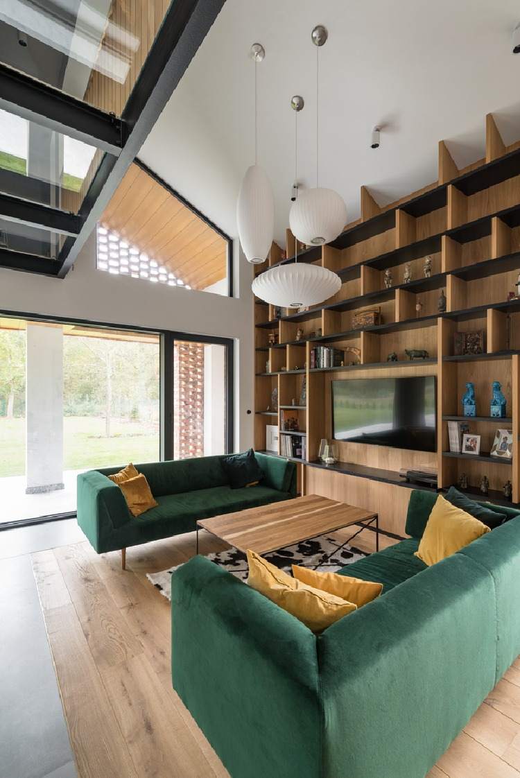 hyggelig stemning i stuen med en grøn sofa og træhylder