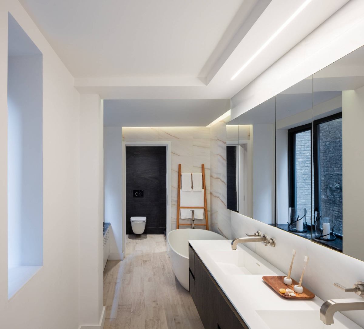 Indretning med strømlinet luksus i det lange badeværelse med træelementer