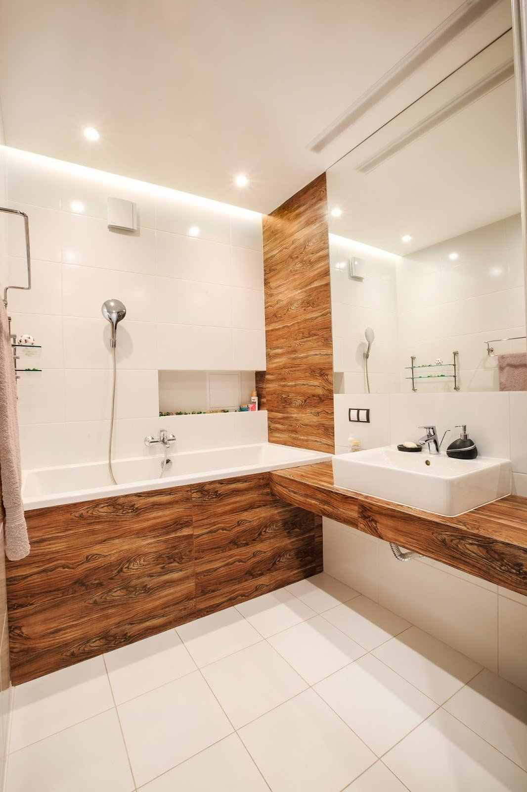 badeværelse hvidt med træpanel af badekaret håndvask indirekte belysning på loftet