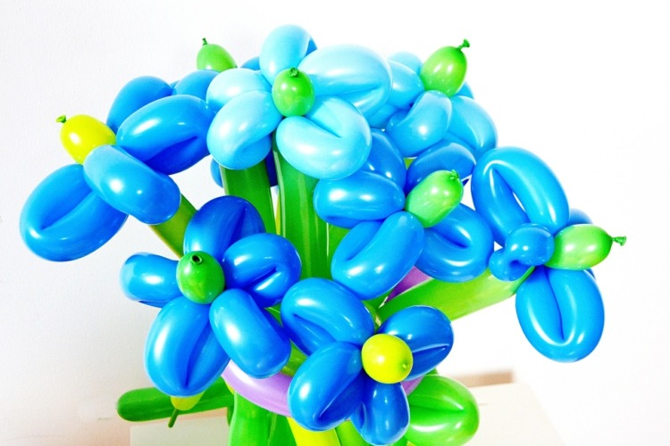 Binder blå blomster fra balloner til en buket