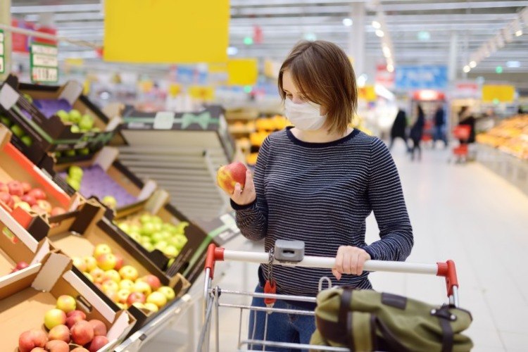 kvinde iført beskyttelsesmaske, mens hun handler i supermarkedet på grund af coronavirus