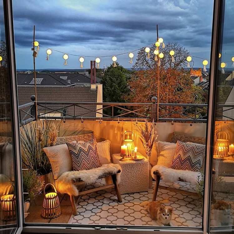 Boho -stil balkon med to lænestole og stemningsfulde lys