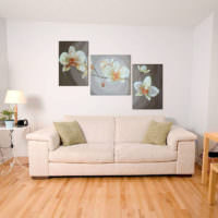 ציורים עם פרחים על הקיר הצבוע של הסלון