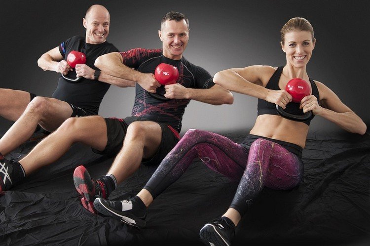 mænd og kvinder på crossfit træning med håndvægte