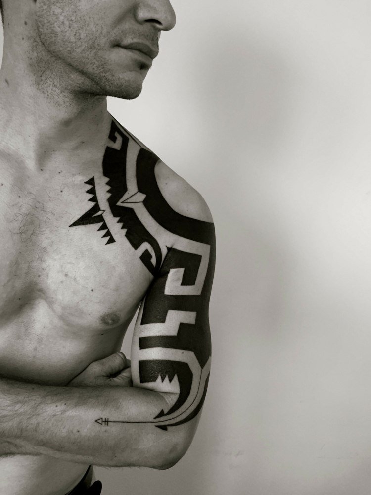 blackwork tatovering tribal mænd skulder overarm pil traditionelle symboler