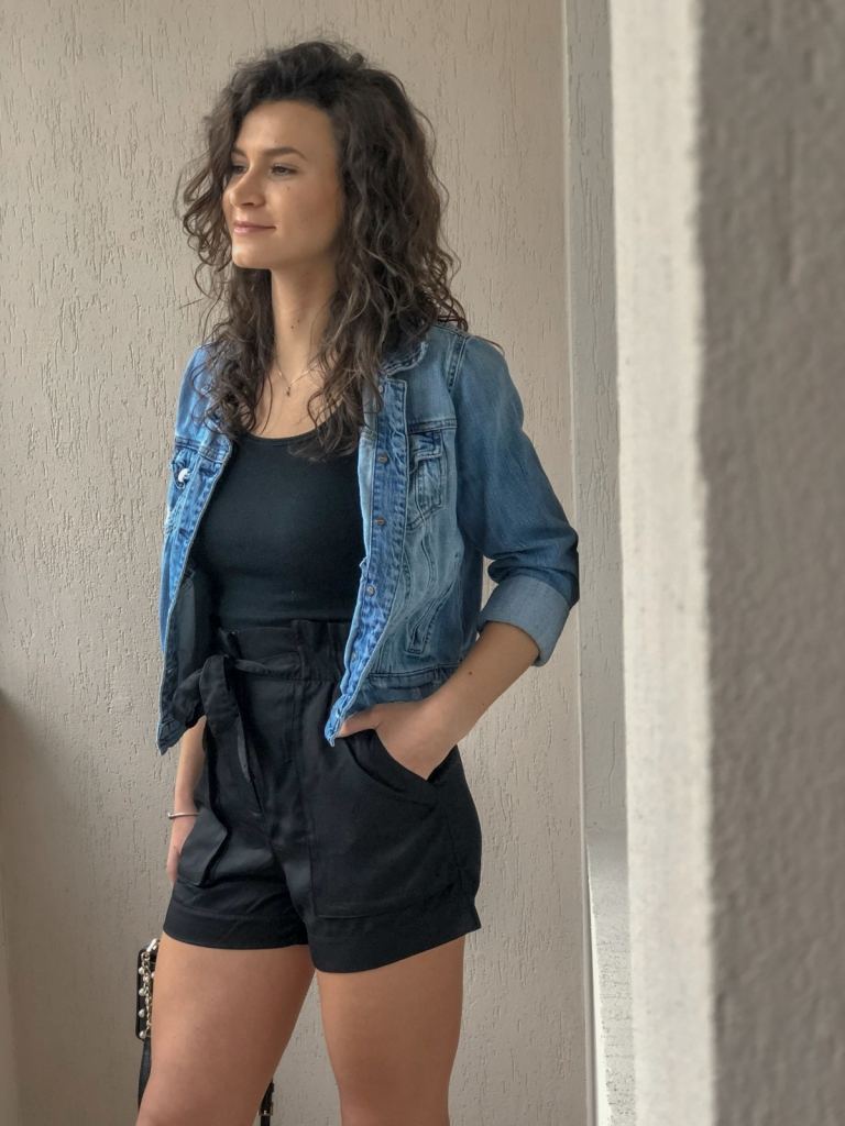 Hverdagsoutfit med sorte shorts og top og denimjakke