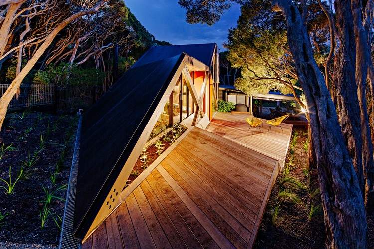 design sommerhus skråtag kystskov moderne bjerghytte moonah træer træ veranda belysning