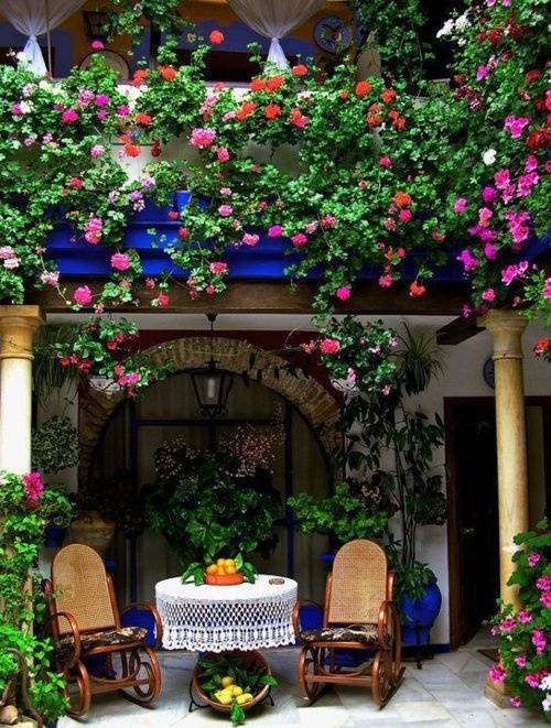 overdækket veranda gyngestole blomster facade