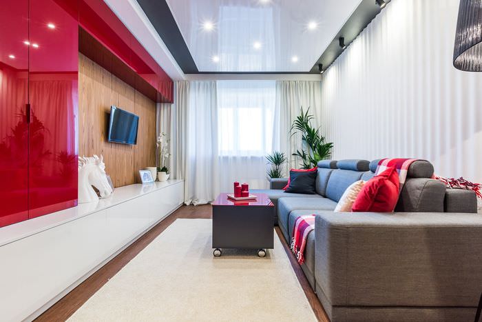 Červená a bílá zeď v úzkém obývacím pokoji