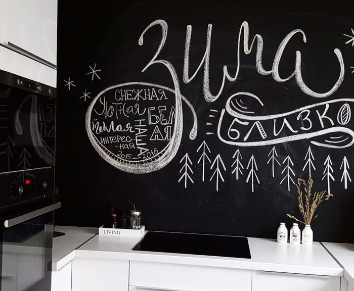Liitu kirjoittaa mustalle keittiön seinälle