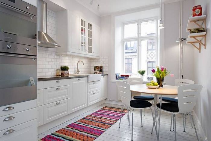 Färgglada matta i det inre av ett vitt kök