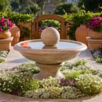 Dekorativ fontene i form av en bolle i hageinnredning