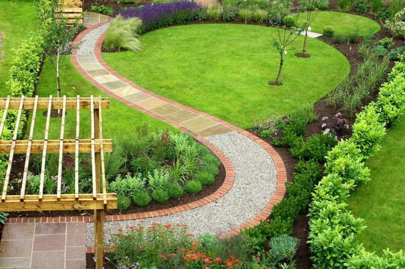Mutkainen puutarhapolku, joka on valmistettu eri materiaalien yhdistelmästä
