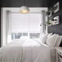 מיטה לבנה בחדר עם קירות אפורים