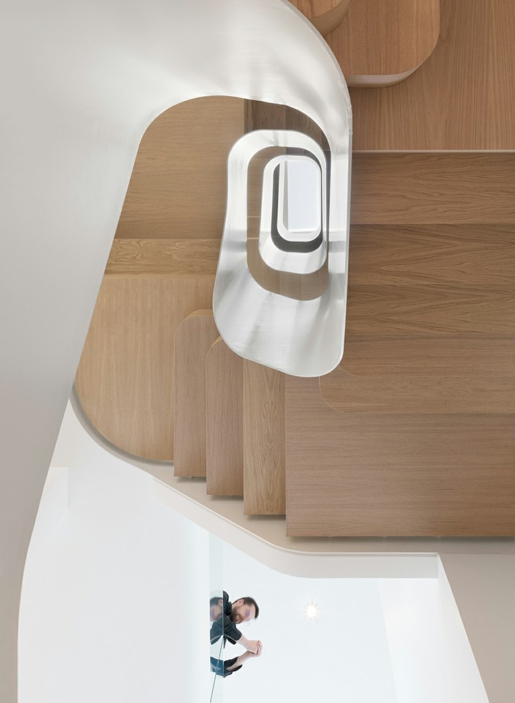 Vindeltrappe i naturligt træ med et åbent design tillader naturligt lys i huset