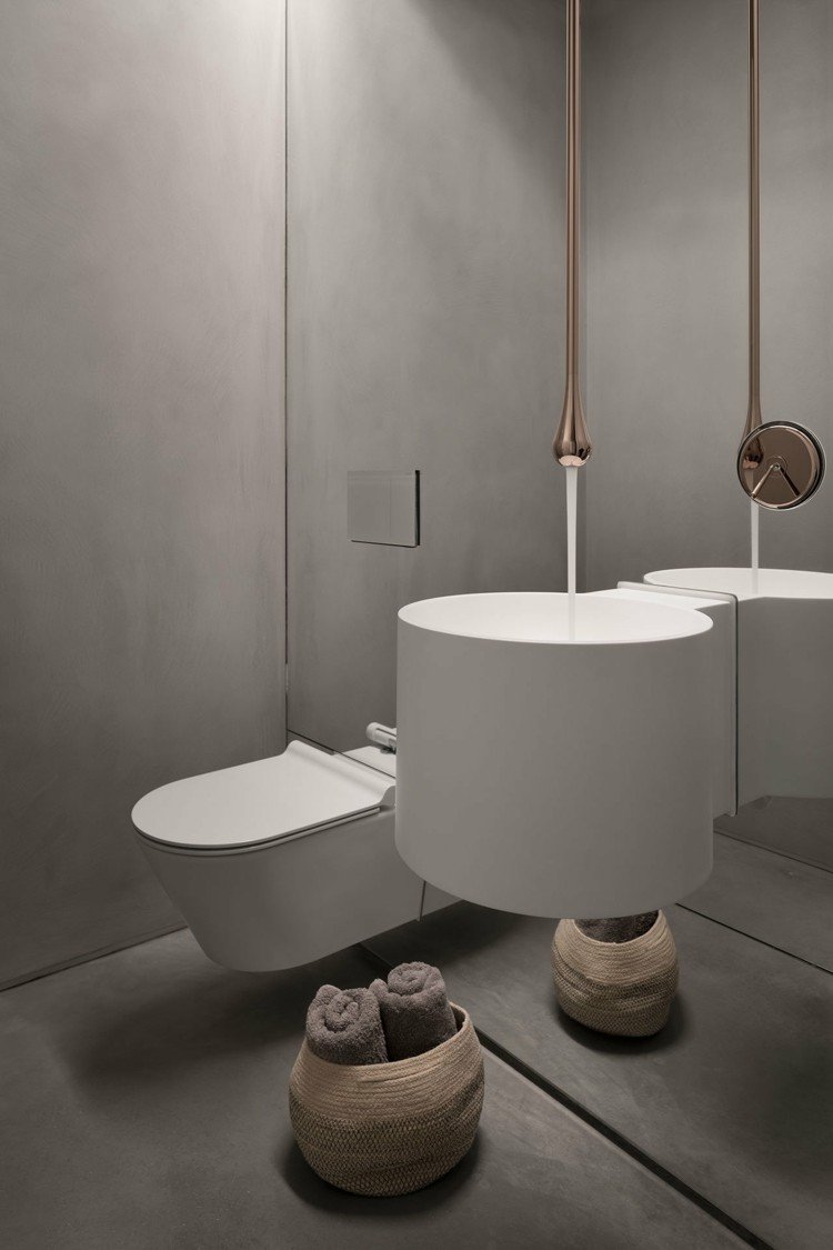 Moderne badeværelse i gråt med kobber accenter og en stor spejlvæg