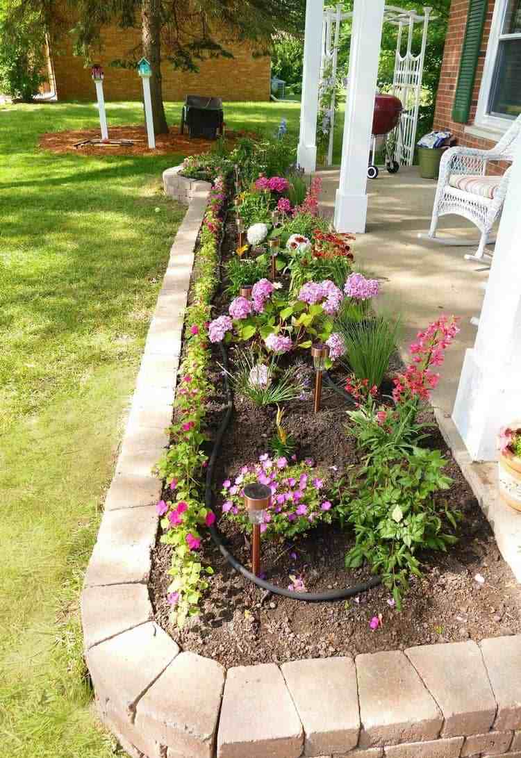 Langt smalt blomsterbed på terrassen