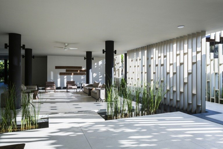 Attraktive rumdelere i form af gitre i hvidt, kombineret med små plantebede i interiøret