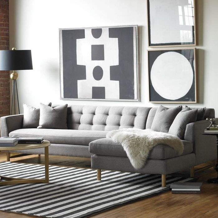 Pelskappe på en grå sofa i en lille stue