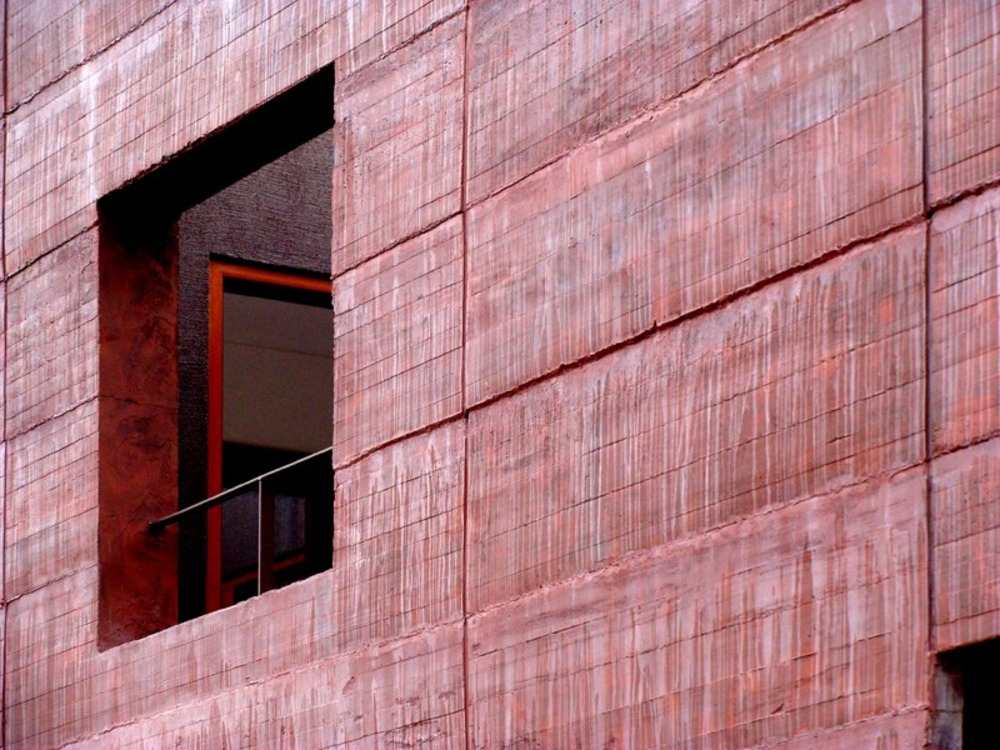 Lag af rød betonvæg bliver bygget til et forstæderhus