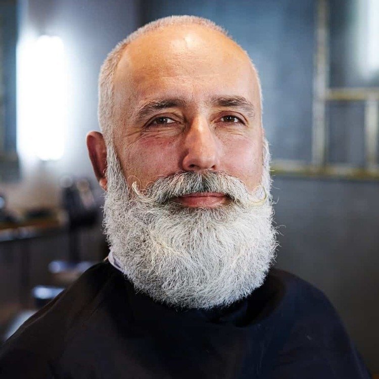 skægget mand med et helt gråt skæg og en kort buzz kut -frisure med tilbagegående hårlinjer