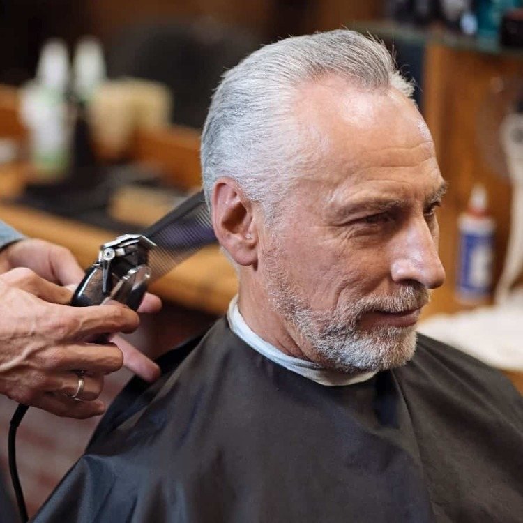 Ældre mand med hvidt hår i frisørsalonen har fået lavet en moderne klipning