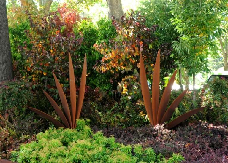 Havedekoration-ideer-moderne-corten stål-havestatue-stedsegrønne planter