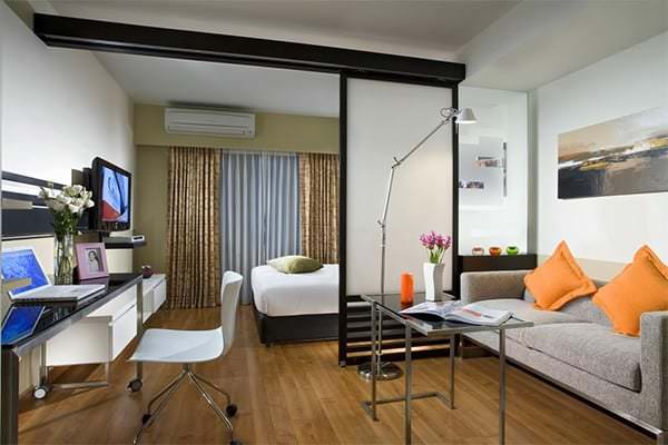 Olohuone ja makuuhuone yhdessä huoneessa 18 m² - kaavoitus, muotoilu, valokuva sängyllä