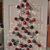 Vianočný stromček vyrobený z farebných guličiek na bielych dverách