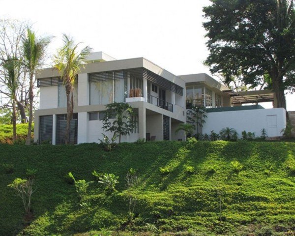 moderne hus bjergskråning hvid facade palmer