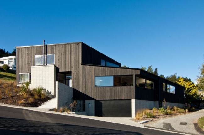Arkitekthusdesign udvendigt cedertræ sort vægbeklædning bygget på bjergskråningen