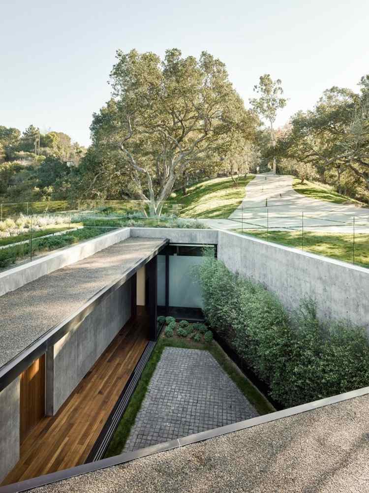 hus lavet af glas og beton gårdhave græsplæne vægplanter parket