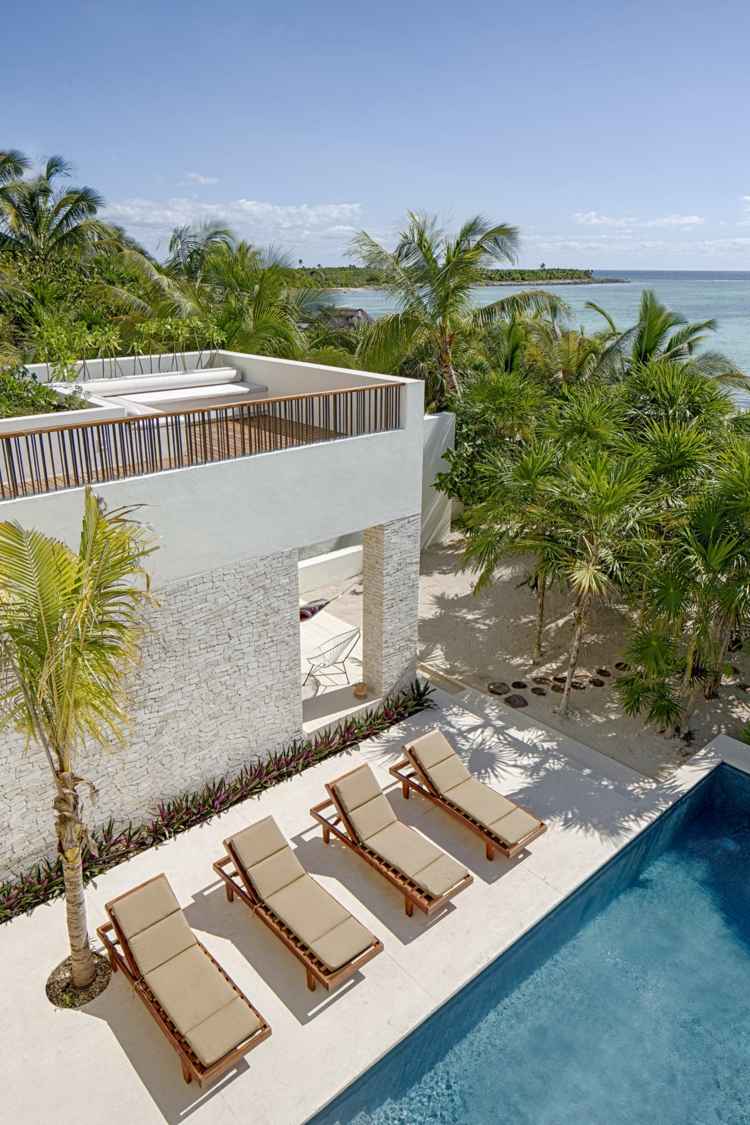 hus med rustikt poolområde solsenge palmetræer terrasse