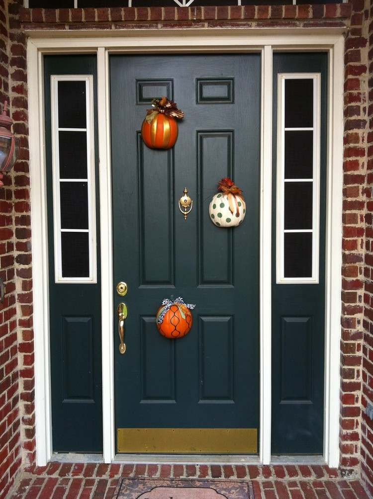 Efterårsdekoration foran husets indgang halveret-græskar-farverig-malet-dørhængt