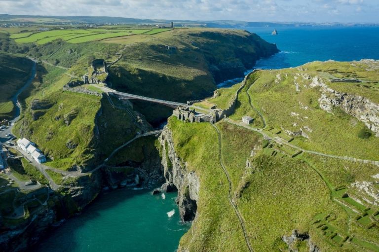 fugleudsigt over cornwall byen tintagel slot med grønne områder og hængebro