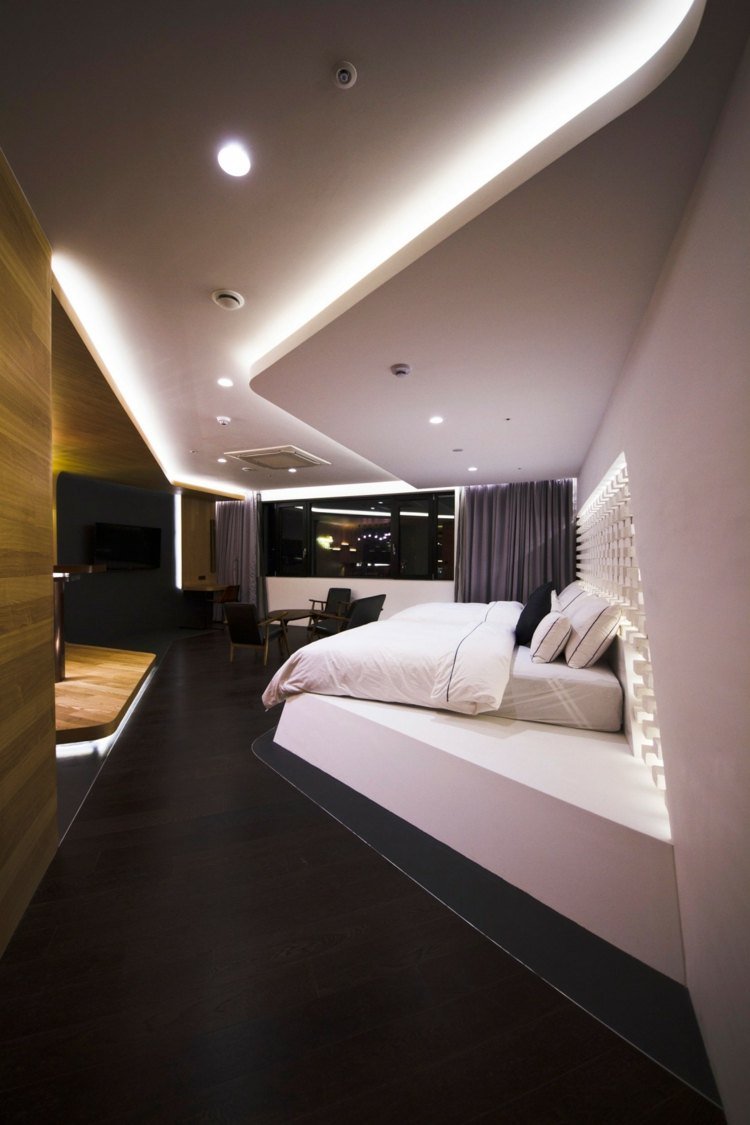 hotelværelse design med indirekte belysning sengetæppe hvidt