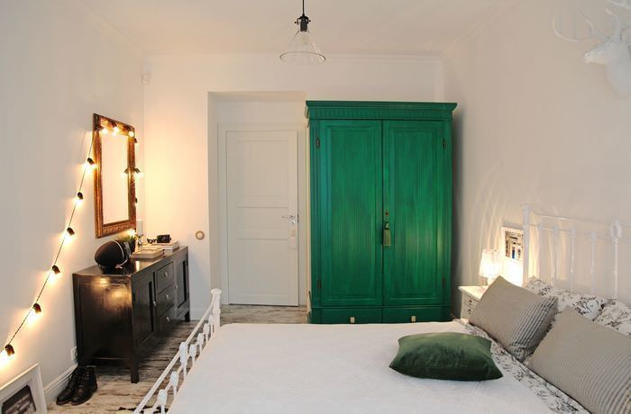 Heller Schlafzimmerinnenraum mit grünem Kleiderschrank