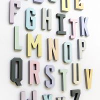 Volumetrische Buchstaben aus Papier an einer weißen Wand