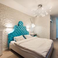 Blå sänggavel i ett vitt sovrum