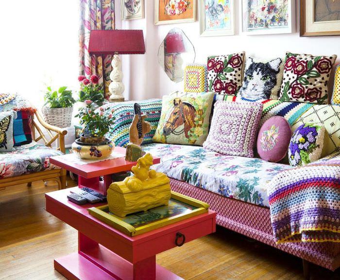 Verschiedene Kissen auf dem Sofa mit bunter Tagesdecke