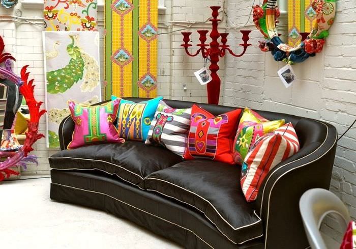 Helle Kissen in auffälligen Farben auf einem dunkelbraunen Sofa