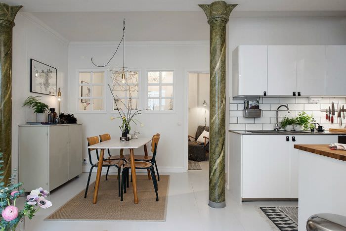 Interior în bucătărie-living în stil scandinav cu coloană de marmură