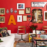 Kirje ja kuvia olohuoneen punaisella seinällä