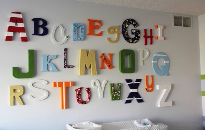 Цветни букви от пяна на стената на хола