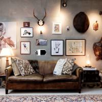 Παλαιός καναπές κοντά σε γκρίζο τοίχο με φωτογραφίες